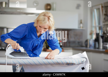 Donna con cautela il marito di stiratura shirt Foto Stock