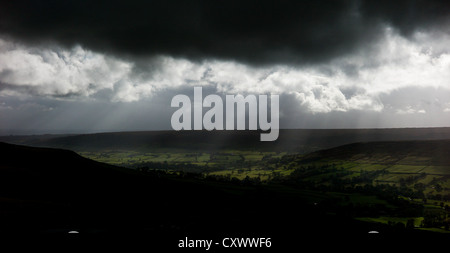 La luce del sole si rompe attraverso nubi e illumina i campi che si affaccia il Rosedale on the North Yorkshire Moors Foto Stock