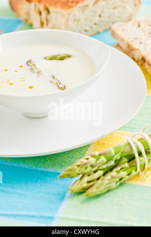 Miscelati cremosa zuppa di asparagi guarnita con asparagi verdi servita con pane Foto Stock