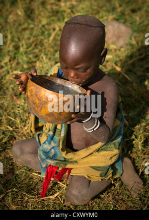 Kid bere latte in Tulgit, Valle dell'Omo, Etiopia Foto Stock