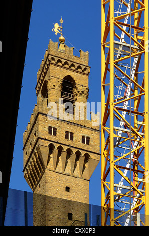 Antico e moderno è contrastata. La struttura di una gru viene mostrato accanto alla torre della Palazzio Vecchio, Firenze, Italia. Foto Stock