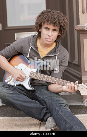 Razza mista adolescente di suonare una chitarra elettrica Foto Stock