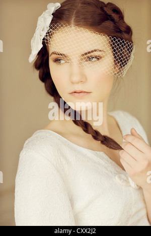 Ritratto di giovane donna con testiera nuziale e capelli intrecciati guardando sopra la sua spalla Foto Stock