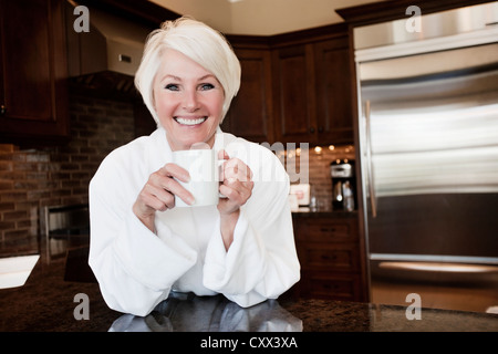 La donna caucasica nel manto di bere il caffè Foto Stock