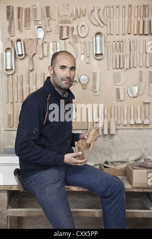 Carpenter holding di legno in officina Foto Stock