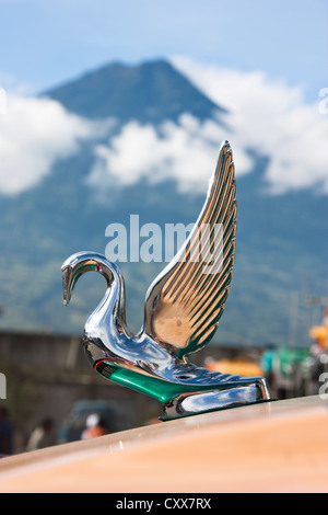 Ornamento del cofano sul bus a Antigua stazione bus dominato da attivo vulcano Fuego. Guatemala, America Centrale Foto Stock