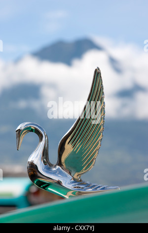 Ornamento del cofano sul bus a Antigua stazione bus dominato da attivo vulcano Fuego. Guatemala, America Centrale Foto Stock