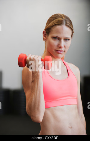 La donna caucasica utilizzando dumbbell Foto Stock