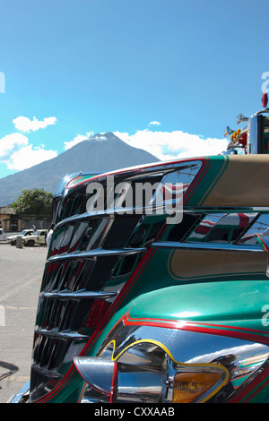 Antigua stazione degli autobus con il vulcano Fuego fumatori nella distanza. Guatemala, America Centrale Foto Stock