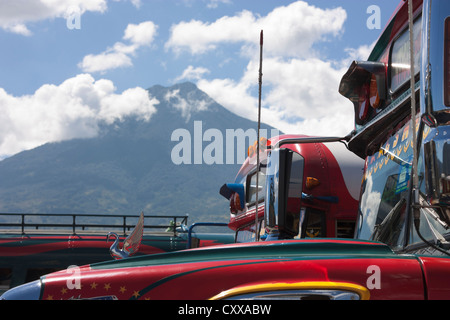 Antigua stazione degli autobus con il vulcano Fuego fumatori nella distanza. Guatemala, America Centrale Foto Stock