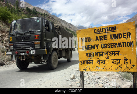 Esercito indiano convoglio militare passa un cartello di segnalazione sull'Kargil pericolosi road vicino alla frontiera pakistana, Kashmir India Foto Stock