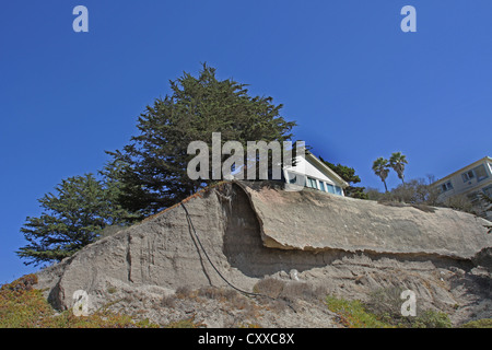 Una casa appollaiato sul bordo di una scogliera di erosione a Pismo Beach, California. Foto Stock