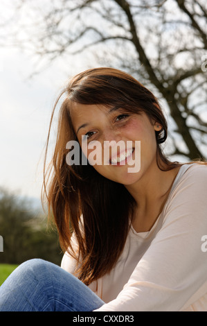 Sorridente giovane donna di origine indonesiana, ritratto, publicground Foto Stock