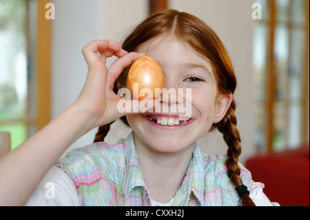 Bambino, ragazza tenendo un colorato uovo di Pasqua Foto Stock