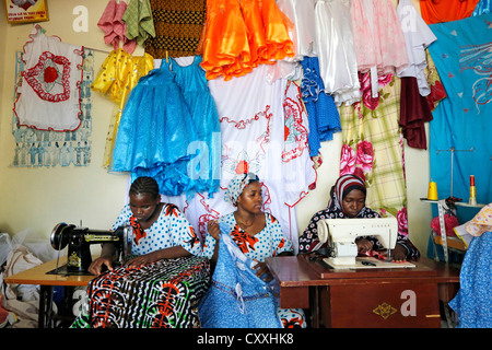 Le donne di macchine da cucire in un negozio di sartoria a Zanzibar / Tanzania Foto Stock