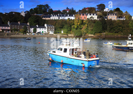 Una colorata barca di piacere nel pittoresco porto di Portree sull'Isola di Skye nelle Highlands Scozzesi. Foto Stock