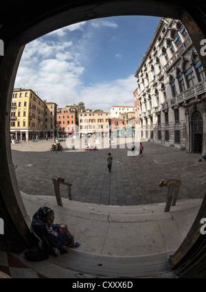 Vista fisheye da i passi della Chiesa di San Geremia Venezia attraverso il campo (quadrato) con un mendicante donna in primo piano Foto Stock