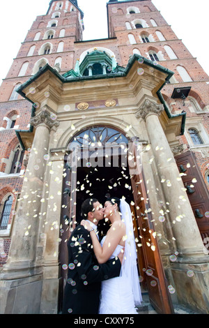 Sposa e lo sposo, coppia di sposi che si baciano davanti la chiesa di Santa Maria, Cracovia, in Polonia, in Europa Foto Stock