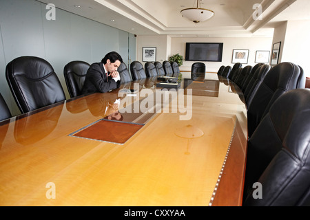 Imprenditore ispanica in seduta vuota sala conferenza Foto Stock