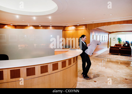 Razza mista imprenditrice leggendo il giornale in ufficio Foto Stock