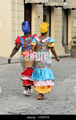 Due donne Creole indossando abiti colorati a piedi nel centro di Avana, Cuba, Antille Maggiori, America Centrale, America Foto Stock