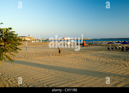 Uomo sabbia di livellamento del campo da pallavolo sulla spiaggia di Rethymnon Creta Grecia Foto Stock