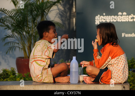 Due bambini cambogiani mangiare, Phnom Penh, Cambogia, Asia Foto Stock