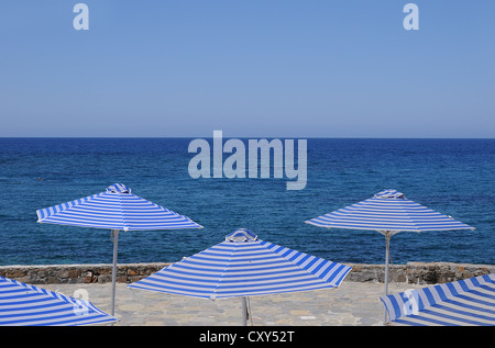 Bianco-blu striato di sdraio e ombrelloni, Creta, Grecia, Europa PublicGround Foto Stock