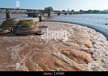 In Oklahoma Tulsa, Arkansas River acqua in esecuzione su uno stramazzo, vecchio ponte ferroviario ora un pedone e pista ciclabile. Foto Stock