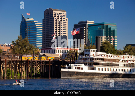 Il centro di Sacramento dello skyline della città sul fiume Sacramento, compreso il Delta King in barca sul fiume. Foto Stock