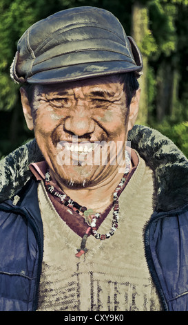 Vecchio nepalese uomo buddista, ritratto, sorridente, con cappuccio, di fronte alla fotocamera, copia, spazio all'aperto, la luce del sole, Foto Stock