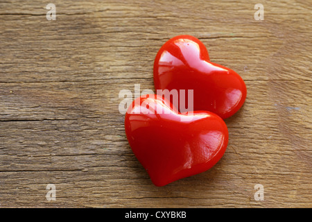 Due cuori rossi su sfondo di legno Foto Stock