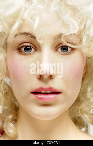 Giovane donna con ricci capelli biondi, ritratto Foto Stock