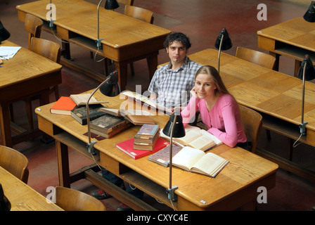 Gli studenti che studiano presso una scrivania in una biblioteca universitaria Foto Stock