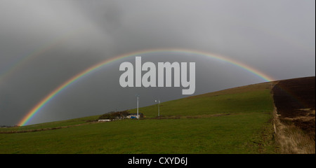 Rainbow su cottage con 2 turbine eoliche Foto Stock