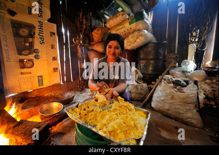 La donna prepara il piatto tradizionale 'Bory Bory' in una cucina semplice su un fuoco aperto, zuppa con gnocchetti di mais Foto Stock