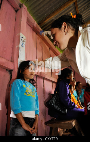 L'altezza di una ragazza che è misurato, una organizzazione di aiuti esaminando i bambini in una comunità rurale, Comunidad Martillo Foto Stock