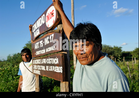 Leader del villaggio Onedi in piedi accanto ad un cartello d'ingresso al suo villaggio, indigeni Pilaga persone, Gran Chaco Foto Stock