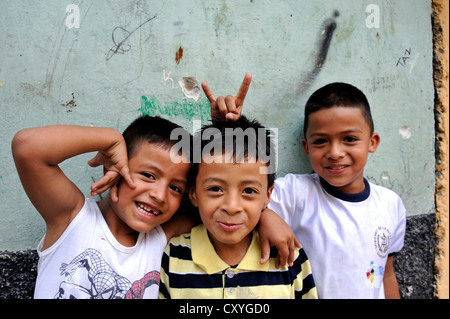 Bullet fori nelle pareti delle case e tre bambini sorridenti, il quartiere povero di El Esfuerzo è controllato dal Foto Stock