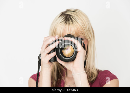 Giovane donna scattare una fotografia con una fotocamera reflex Foto Stock
