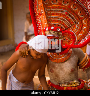 Persone di porre domande circa il futuro durante la cerimonia Theyyam, Thalassery, India Foto Stock