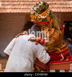 Persone di porre domande circa il futuro durante la cerimonia Theyyam, Thalassery, India Foto Stock