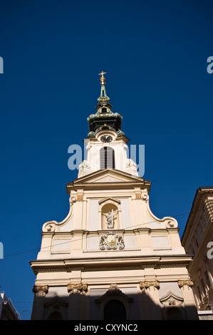 La torre della Stiftskirche su Mariahilfer Strasse, Vienna, Austria Foto Stock