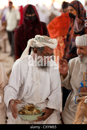 L'uomo scherzando con il miele del venditore nel mercato Sinaw, Oman Foto Stock