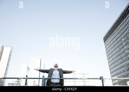 Giovane imprenditore felicemente allargando le braccia Foto Stock