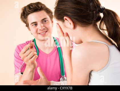 Ragazza la ricezione di farmaco dal suo pediatra Foto Stock