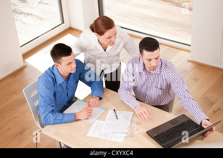 Team di Office avente un incontro intorno a una scrivania Foto Stock