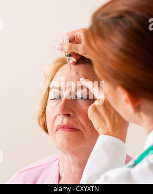 Paziente che riceve una iniezione nel suo volto da un medico Foto Stock