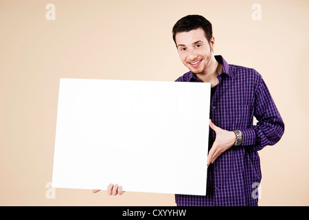 Giovane uomo in possesso di una scheda vuota Foto Stock