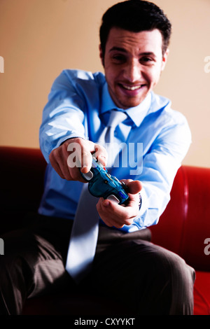Giovane uomo giocando su una console di gioco Foto Stock
